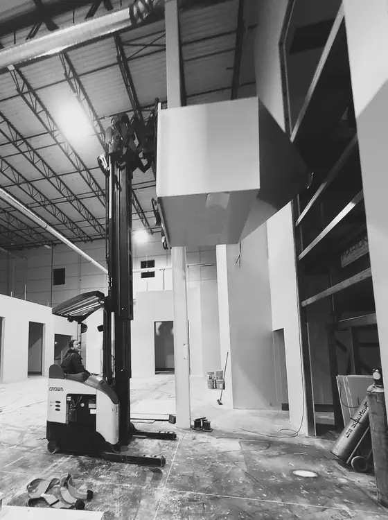 Wetzel Welding installing a large fabricated enclosure using a reach forklift
